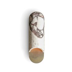 a white and brown marble tube on a white background with an orange circle in the middle