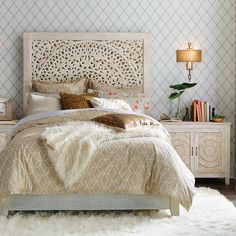 a bedroom with a bed, nightstands and lamps on either side of the bed