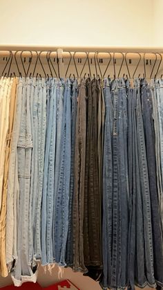 several pairs of jeans are hanging on a rack