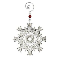 a snowflake ornament hanging from a metal hook on a white background