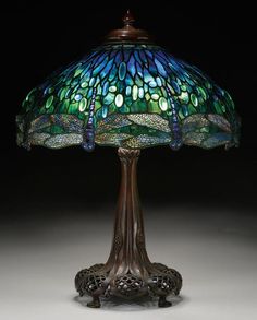 a table lamp with a blue and green dragonfly on it's glass shade