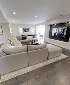 a large living room with two couches and a flat screen tv on the wall