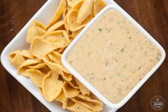 a white bowl filled with tortilla chips next to a container of salsa dip