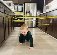 a little boy crawling on the kitchen floor