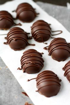 chocolate covered candies sitting on top of a piece of parchment paper