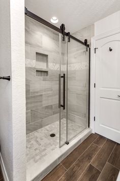 a walk in shower sitting next to a white door