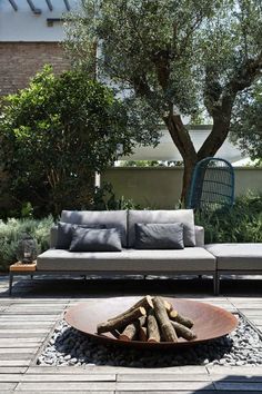 a couch sitting on top of a wooden floor next to a fire pit