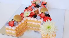 a piece of cake with strawberries and flowers on the top is cut in half