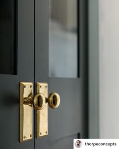 a close up of a door handle on a black door with gold handles and knobs