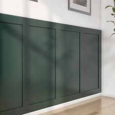 an empty room with green cabinets and a potted plant on the floor next to it