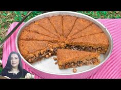 there is a pie that has been cut in half on the table with a woman sitting next to it