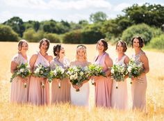 a group of women standing next to each other in a field