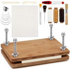 a wooden cutting board with sewing supplies on it