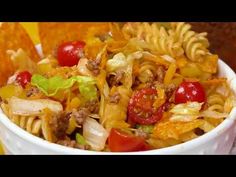 a white bowl filled with pasta salad and tortilla chips on top of a table