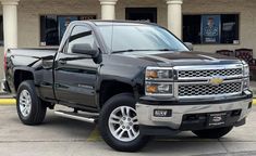 a black truck parked in front of a building