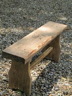 a wooden bench sitting on top of a pile of rocks