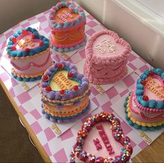 a table topped with lots of cakes covered in frosting