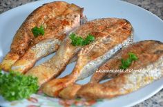 some fish are sitting on a plate with parsley around it and ready to be eaten