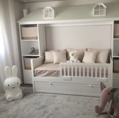 a child's bedroom with white furniture and pink accessories, including a toy elephant