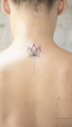 the back of a woman's neck with a lotus tattoo on it