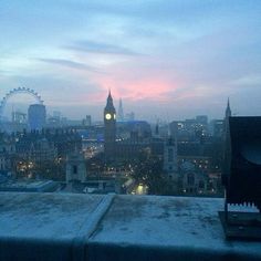 a view of the london skyline at dusk from a rooftop top restaurant in central london