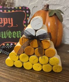 a stack of firewood sitting on top of a wooden table next to a happy halloween sign