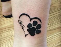 a dog paw and heart tattoo on the leg for someone's love or family