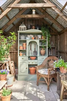 an old fashioned hut with potted plants and pots on the shelves in front of it