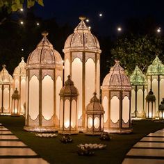 an elaborately decorated lawn with lit up lanterns in the shape of pagodas at night