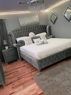 a large bed sitting in the middle of a bedroom next to a dresser and mirror