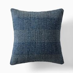 a blue pillow on a white wall