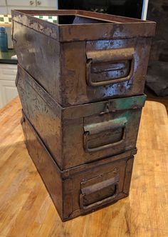 an old metal box sitting on top of a wooden table