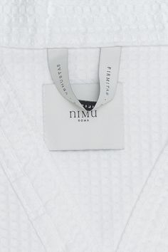 a white shirt with a tag on the front and back of it that says nimu