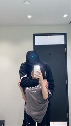 a man and woman taking a selfie in front of a mirror with their arms around each other