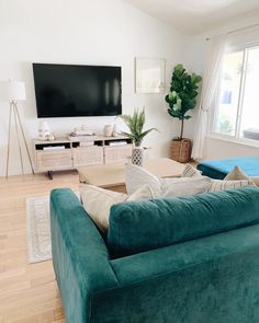 a living room filled with furniture and a flat screen tv mounted on the wall above it