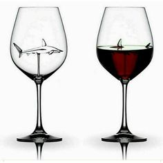 two wine glasses filled with red liquid and a shark in the glass are shown side by side