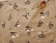 a wooden spoon sitting on top of a piece of cloth covered in snowman designs