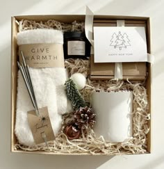 a gift box with candles, coffee mug and other items