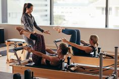 three women doing pivots on rowing machines in a gym