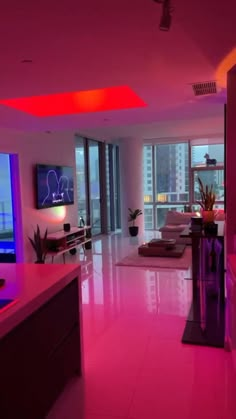 a living room filled with furniture and pink lighting