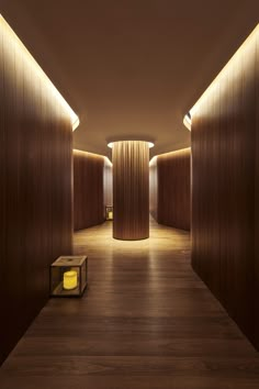 an empty hallway with wooden walls and lights