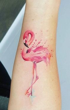 a watercolor flamingo tattoo on the left arm and wrist is shown in pink