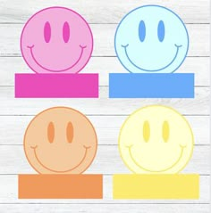 three smiley faces sitting on top of each other in front of a white wooden background