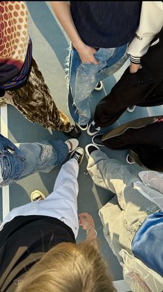 a group of people standing in a circle with their feet on each other's legs