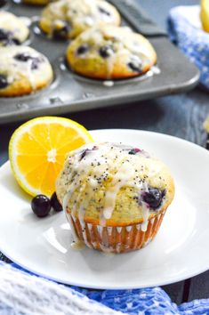 lemon blueberry muffins on a white plate next to a cupcake tin