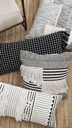 three pillows are laying on the floor next to each other, one is black and white