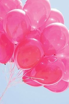 a bunch of pink balloons floating in the air