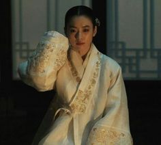 a woman dressed in traditional chinese clothing poses for the camera