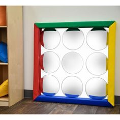 a child's play area with toys and bookshelves on the floor in front of it