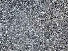 an asphalt surface is shown with small rocks and gravel on the ground, as if it were made out of cement